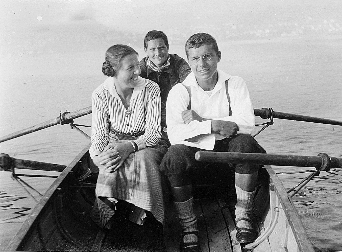 Drei Wandervögel sitzen auf einem Ruderboot, ein Wandervogel rudernd (1914)