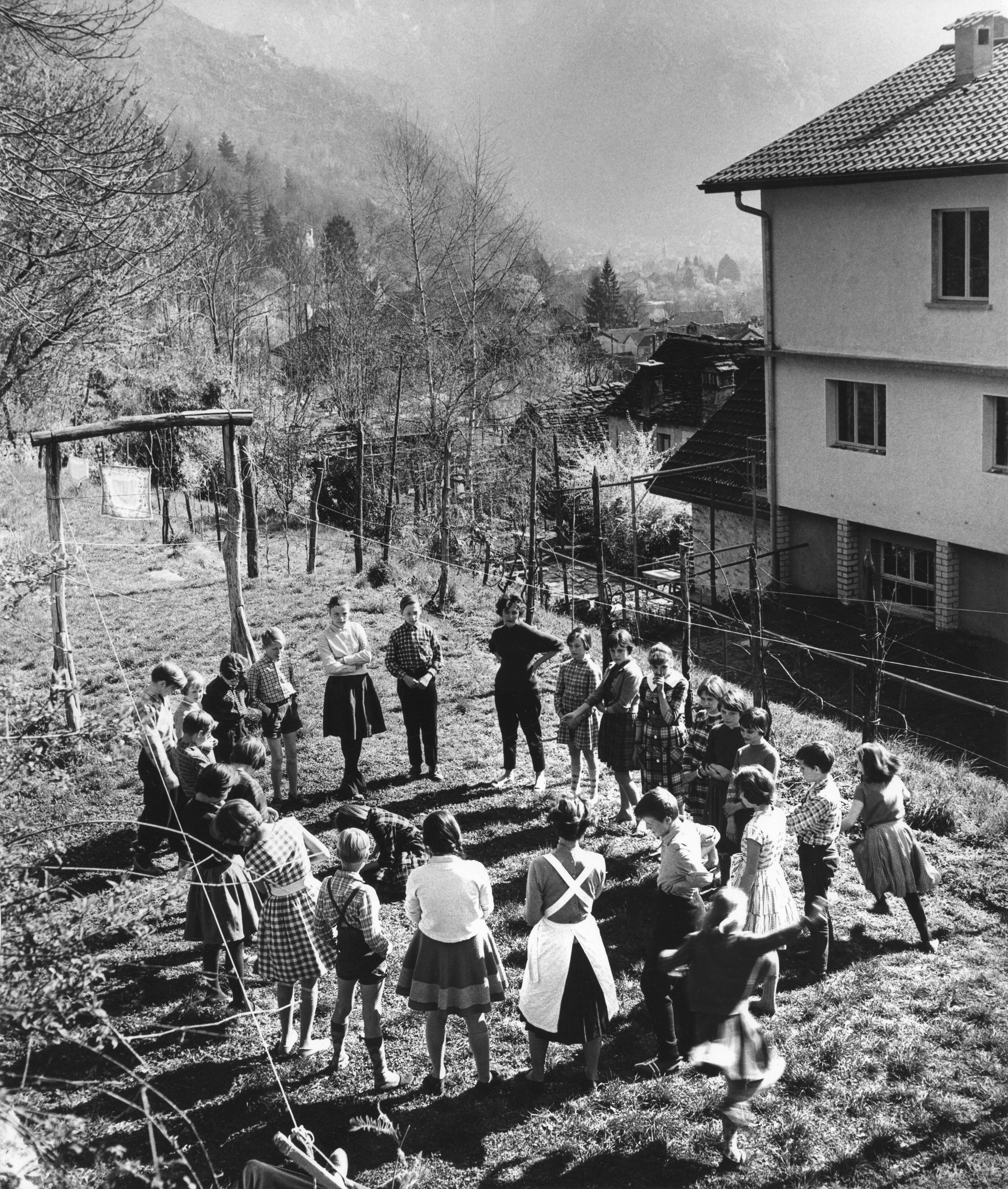 Berliner Flüchtlingskinder in der Casa solidarietà; Betreuerinnen und Kinder spielen vor dem Heim auf einer Wiese