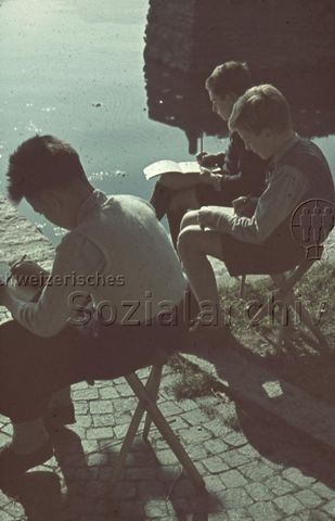 "Zeichenunterricht im Freien" - Drei Jungen beim Zeichnen am See; um 1965