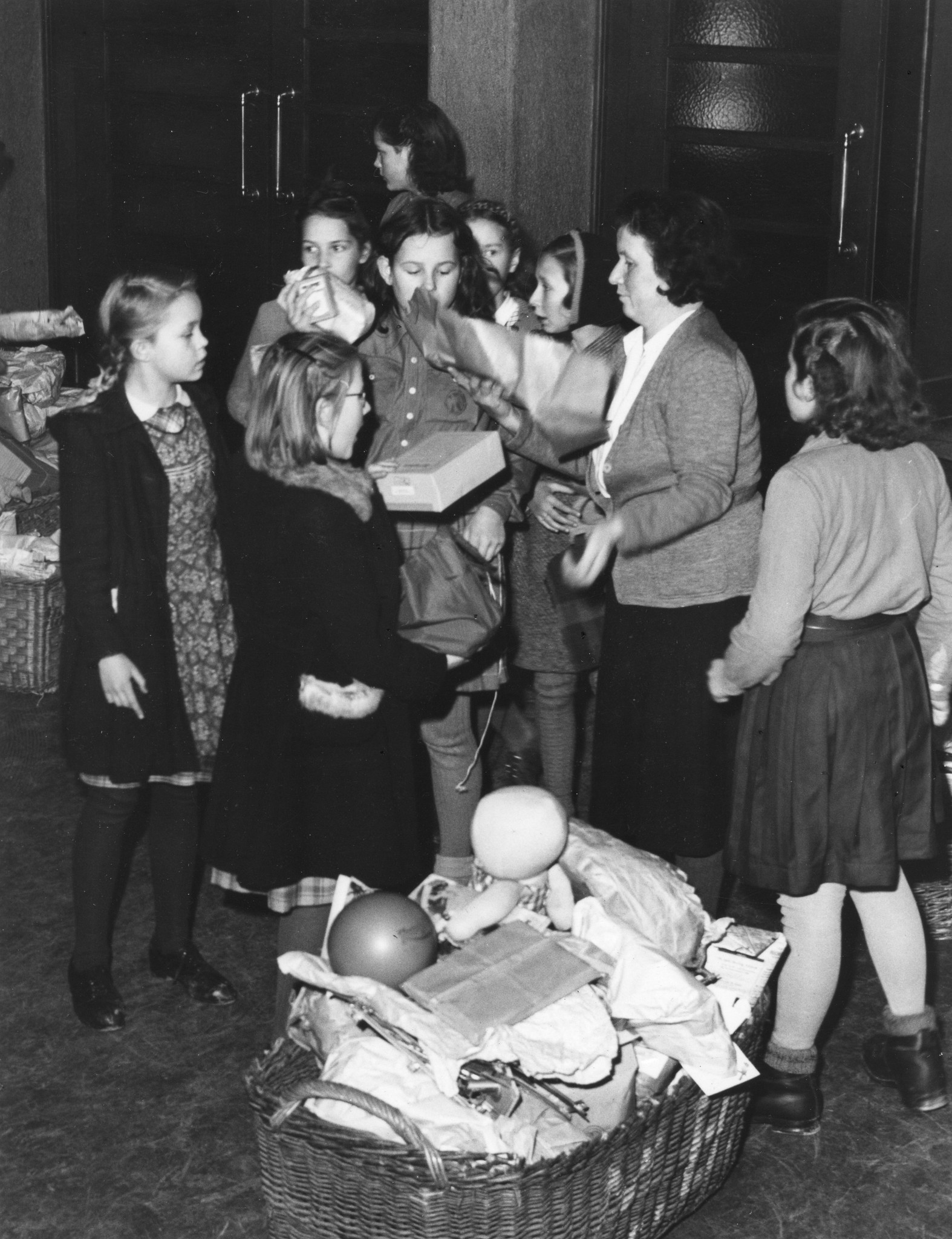 "November 1946, Spielzeugsammlung für unsere Auslandkinderheime, verbunden mit einer Kindervorstellung im Volkshaus Zürich", Kinder mit abzugebenden Spielzeugen und bei der Abgabe ihrer Spielzeugen im Volkshaus