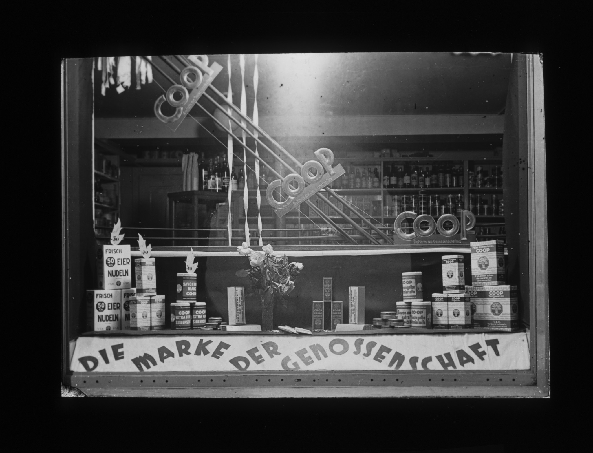 Dia: COOP/LVZ-Filiale: Schaufenster mit Auslage und Text: "COOP Die Marke der Genossenschaft".