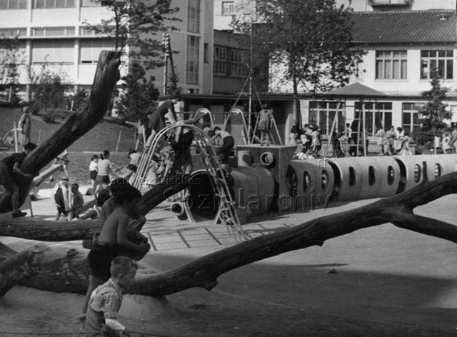 Siedlungsspielplatz Heiligfeld, Letzigraben - "Kletterbaum im Vordergrund, Klettergerät, Röhren-'Eisenbahn', Kletterturm im Hintergrund", spielende Kinder; um 1960