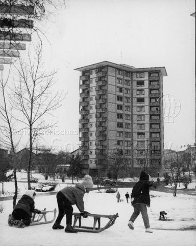 "Siedlungsspielplatz Heiligfeld [Zürich] - schlittelnde Kinder", im Hintergrund ein Wohnblock; 1961/1962