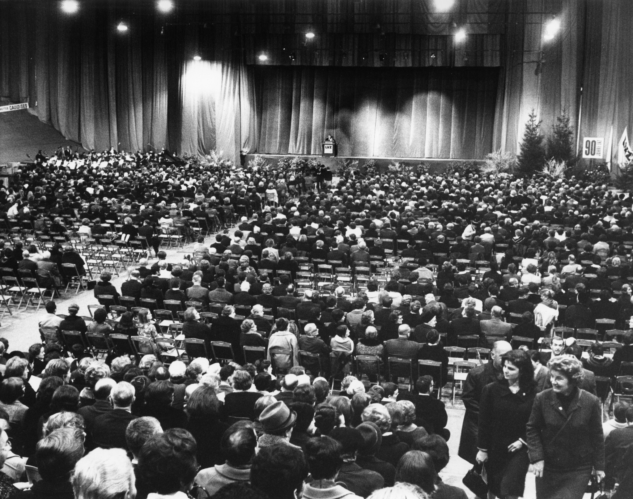 Jubiläum 90 Jahre Lebensmittelverein Zürich 1968: Aufnahme der Besucher auf Sitzreihen und die Bühne mit Redner im Hallenstadion Zürich