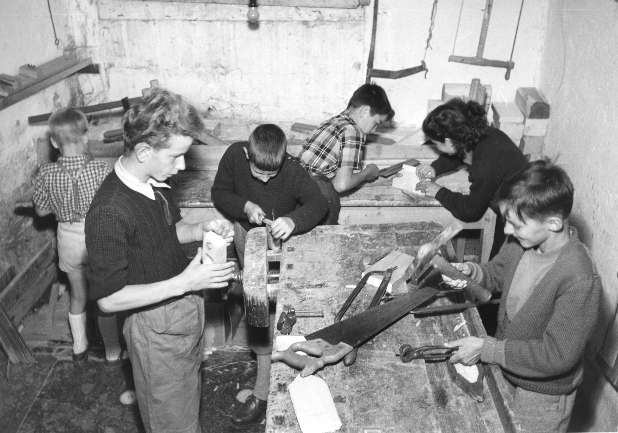 Sechs Kinder arbeiten in einer Werkstatt mit Holz