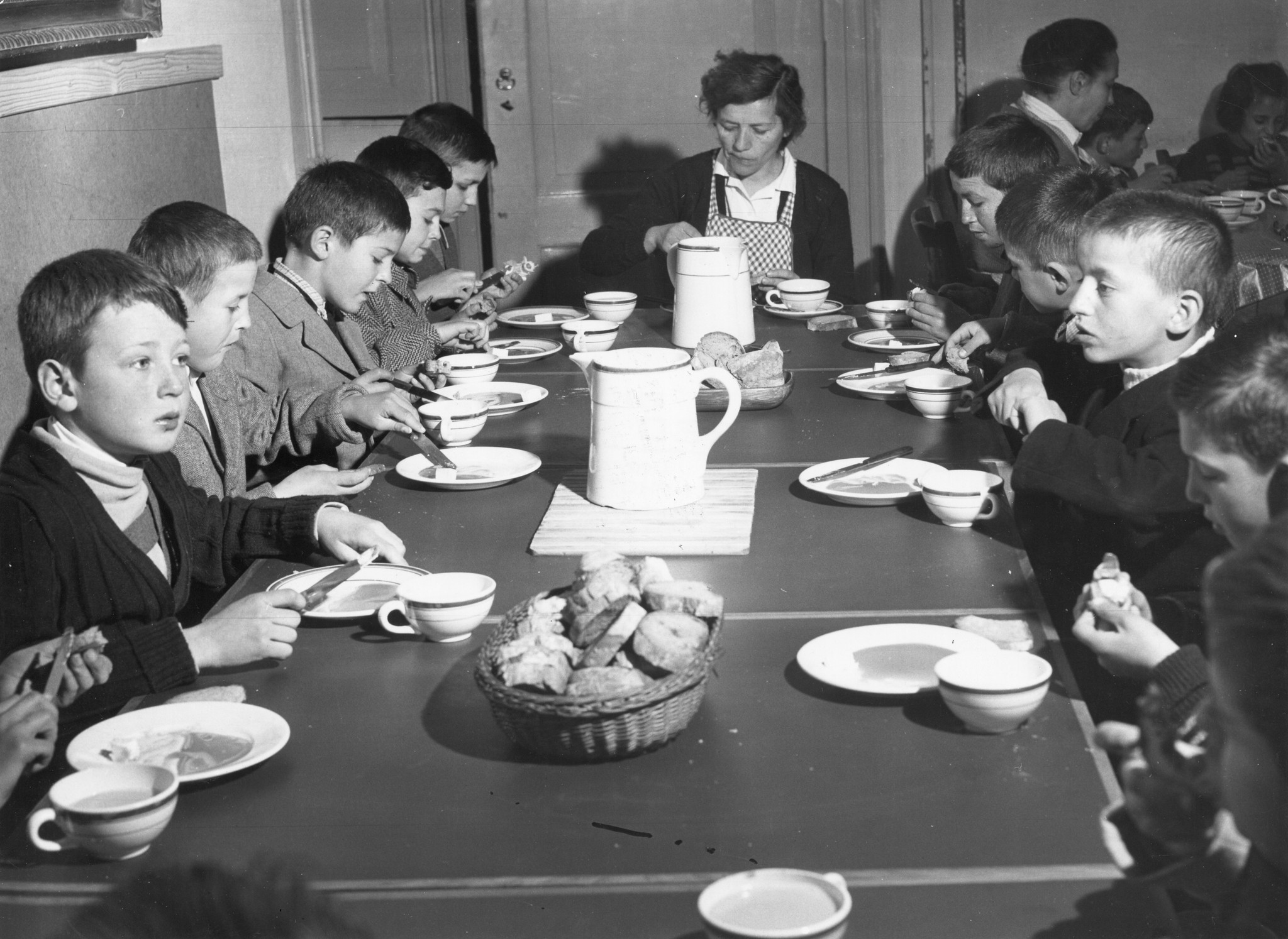 Kinder essen zusammen mit den Betreuern ihr Abendessen
