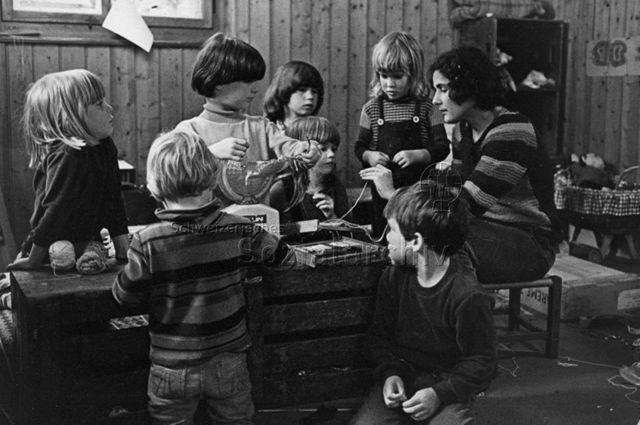 "Kindergarten, Zürich" - Kinder und Kindergärtnerin beim Basteln; um 1970