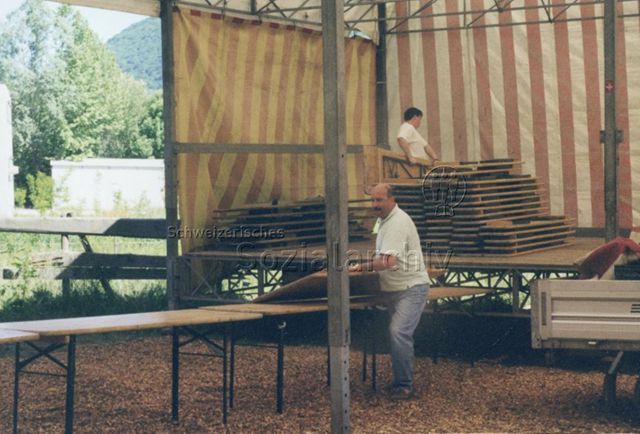 Bosco della Bella, Feriendorf für kinderreiche Familien - Zwei Männer beim Auf- oder Abbauen von Festbänken in einem Festzelt; 2000
