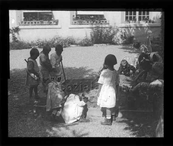 Diaserie zum Thema Kindergarten / Schulkind; Kinder spielen in einem Sandkasten; um 1930