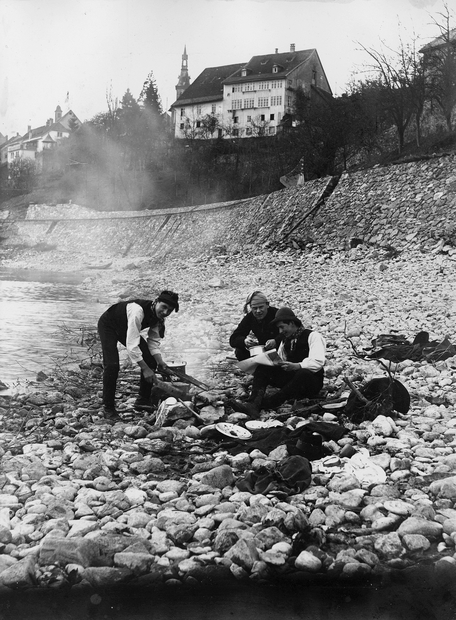 Wandervögel der Ortsgruppe Aarau-Stadt - "Drecktour nach Laufenburg": Drei Wandervögel am Ufer des Rheins ein Feuer vorbereitend (19