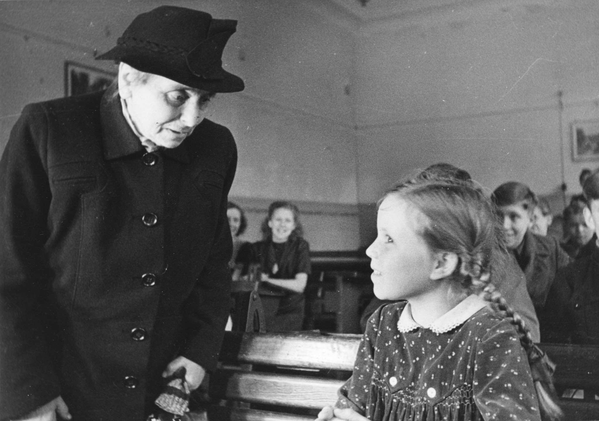 "März 1948: Verteilung von Lebensmittelpaketen am die Schüler der Gemeinschaftsschule Düsseldorf"; Margaretha Kissel-Brutschy (?) mit einem Mädchen sprechend