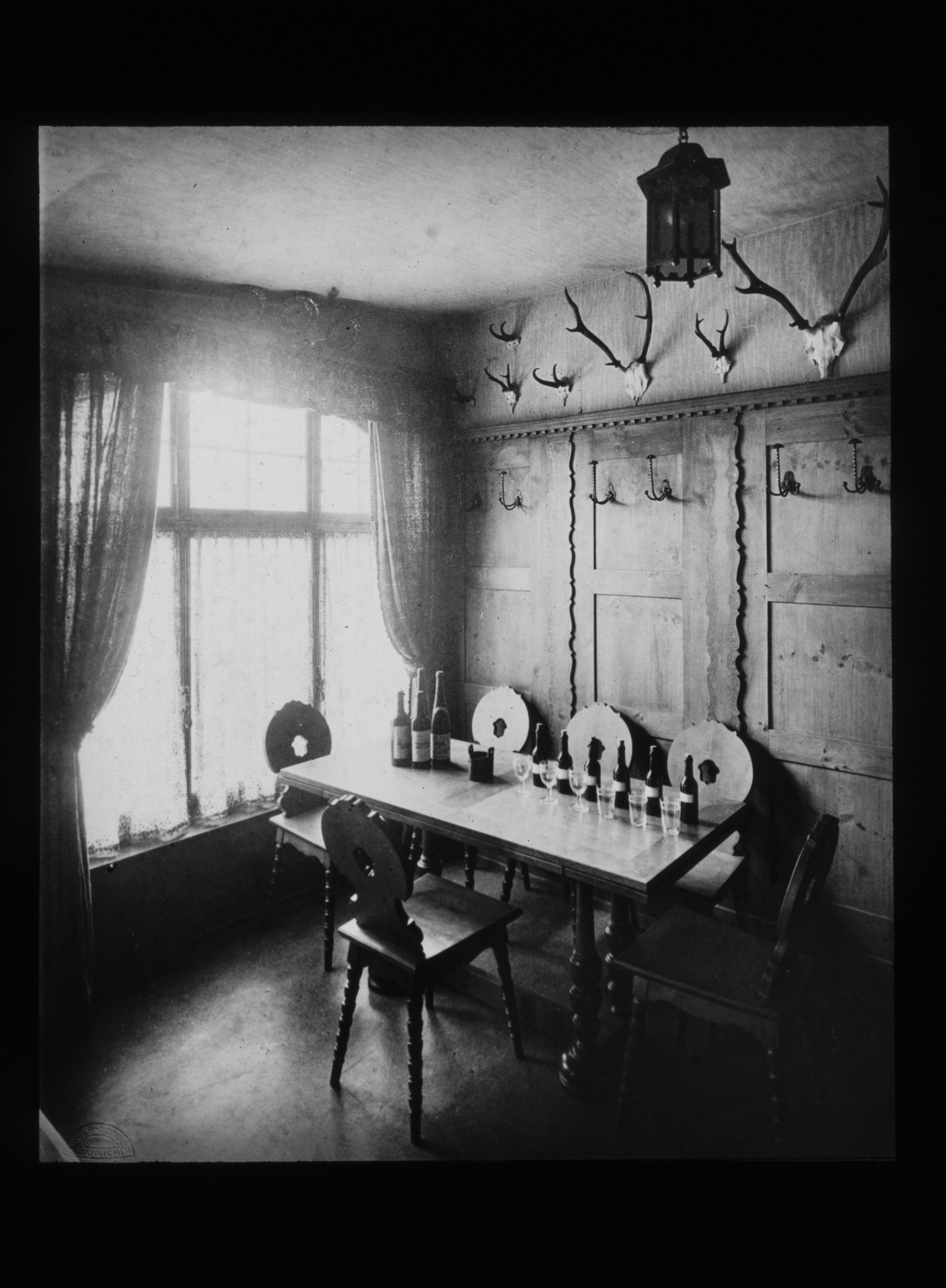 Dia: Kellerei-Stübli des LVZ. Rustikales Zimmer mit Geweihen an der Wand und Wein auf dem Tisch.