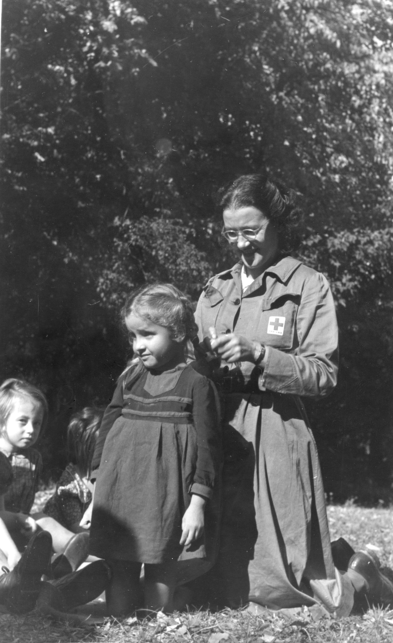 "Wilheminenberg"; eine Betreuerin flechtet einem kleinen Mädchen die Haare