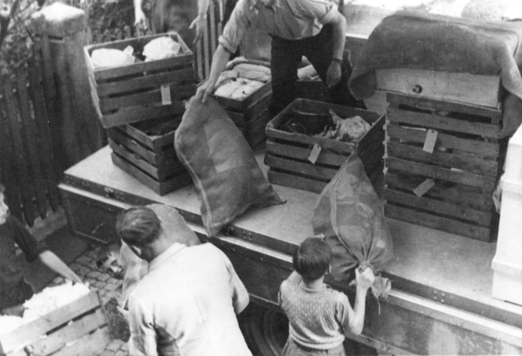 "Zürich, Mai 1946. Der erste Camion aus Schaffhausen kommt an: 80 t. wurden dort gesammelt!"; Männer und Knaben laden die Lieferung von der Ladefläche
