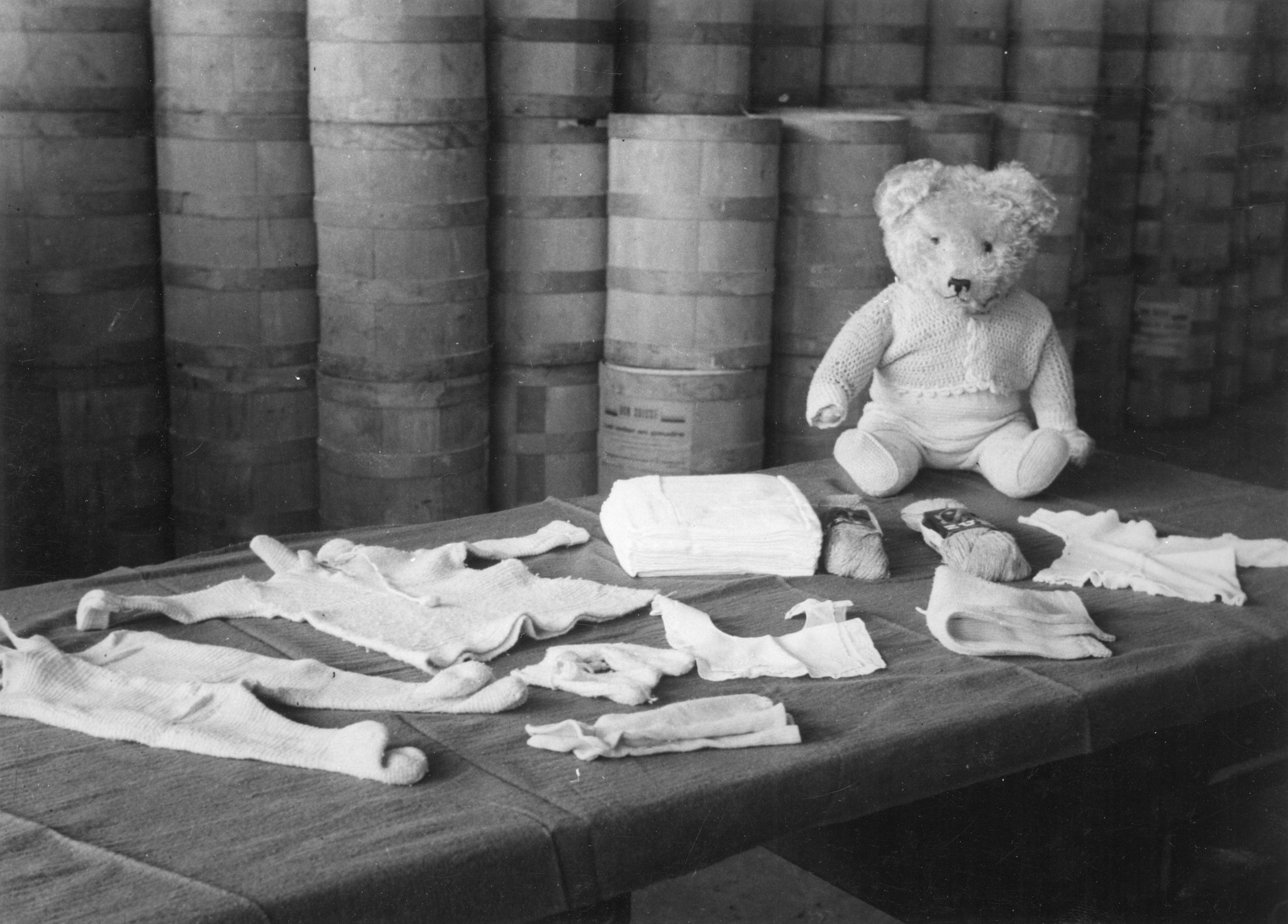 "Lyon 1945. Baby-Ausstattung." Babykleider und Plüschbär