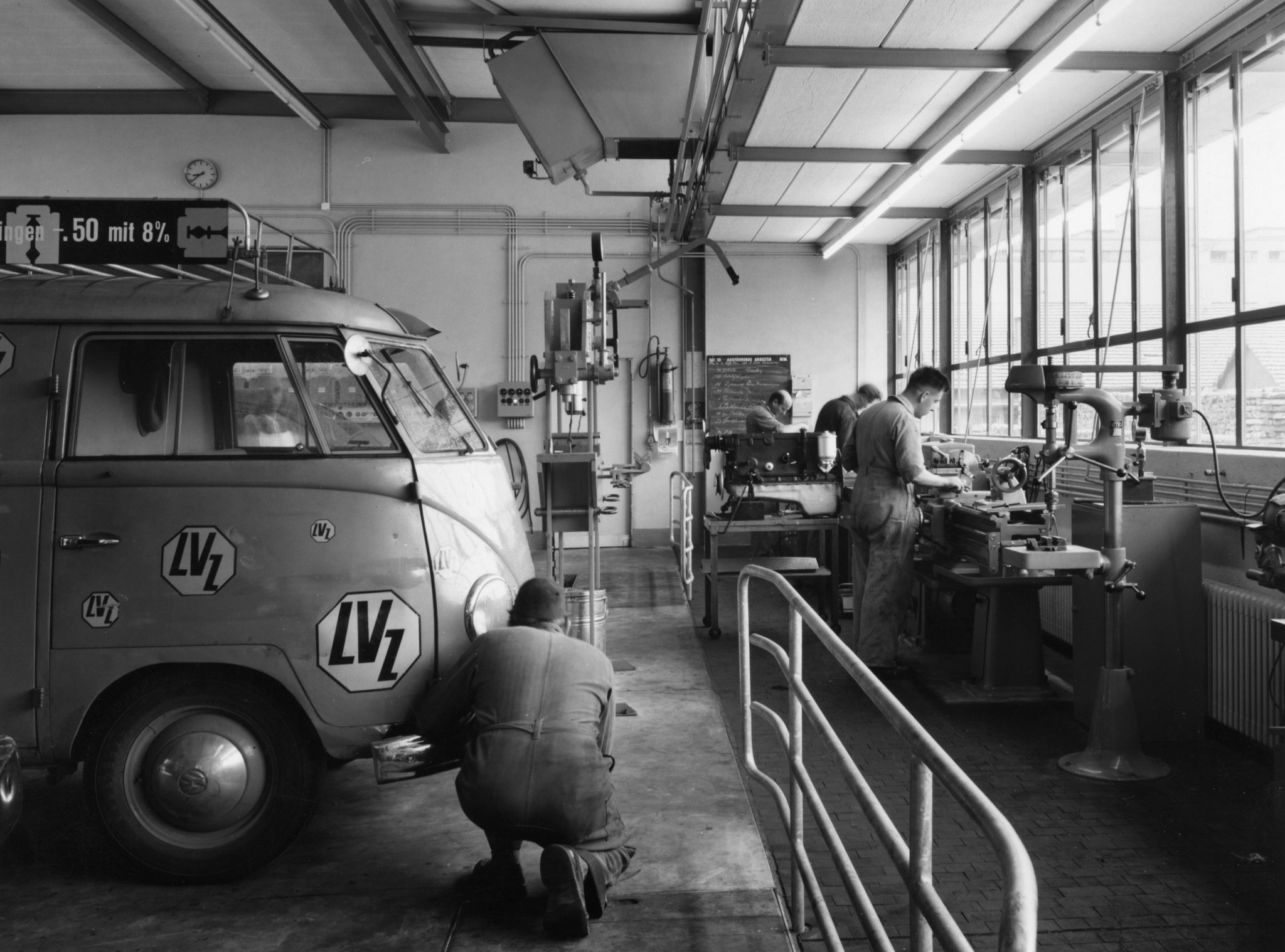 Lieferwagen des Lebensmittelvereins Zürich in einer Werkstätte, Mechaniker bei Reparaturarbeiten