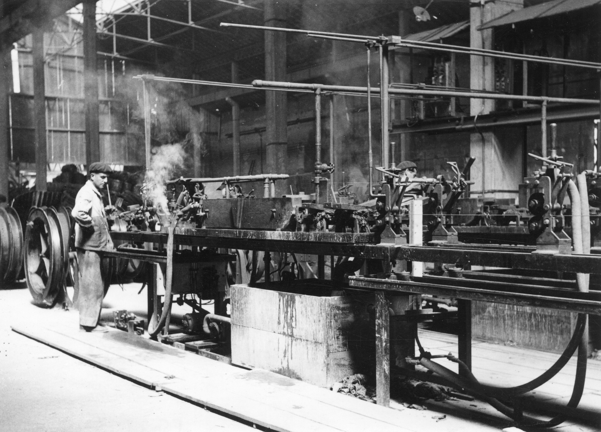 "Lyon 1945. Ansicht der Fabrik TESTE." Arbeiter bei Maschinen in zerbombter Fabrik