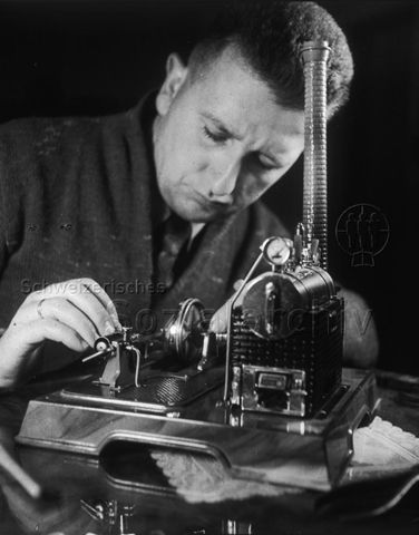 "Dampfmaschine" - Mann bedient die Spielzeug-Maschine; um 1965