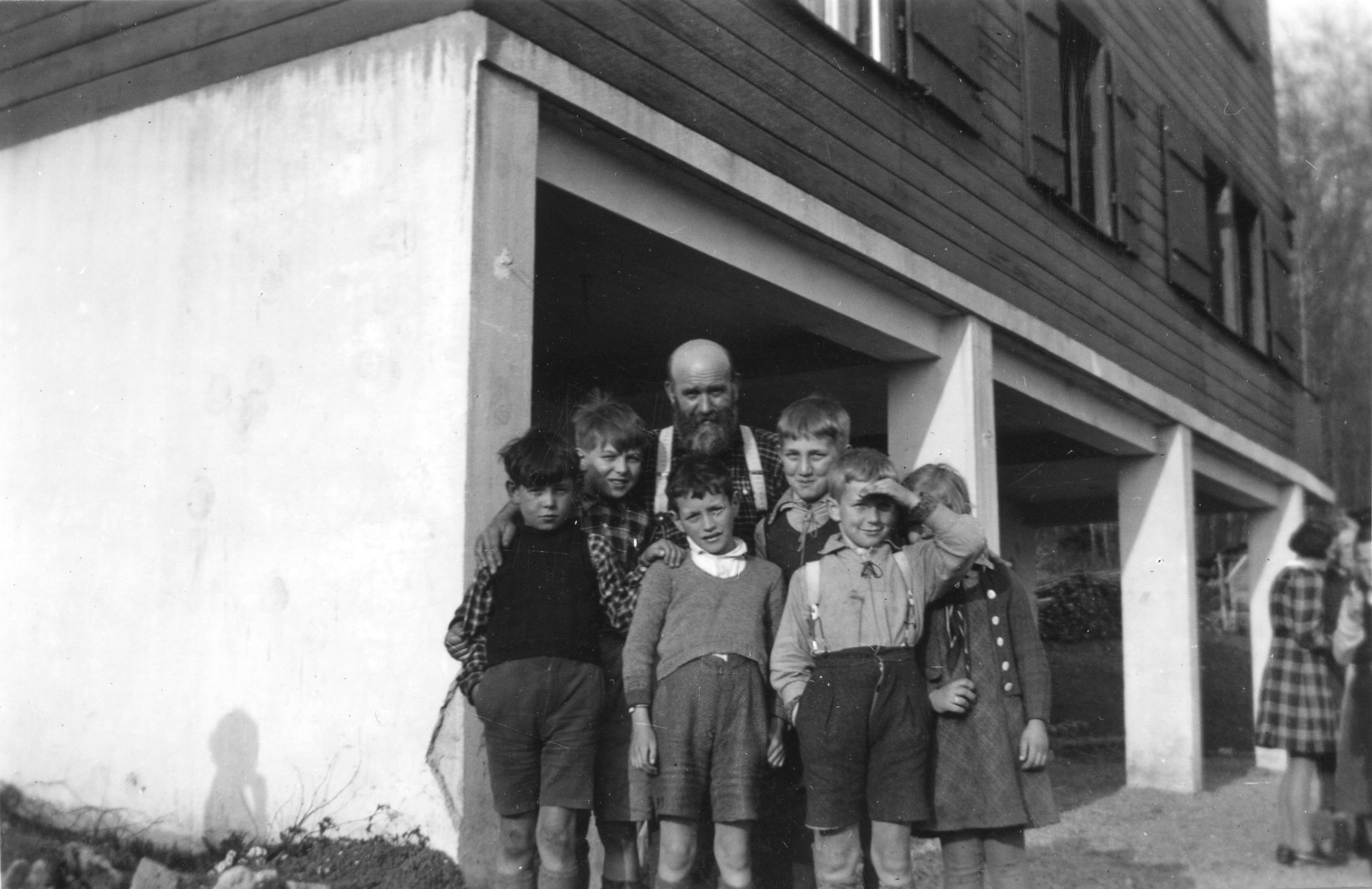 Ein Mann und fünf Kinder posieren vor einem Haus