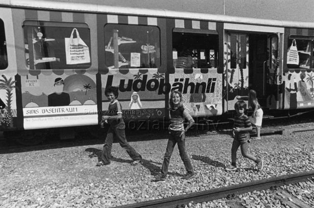 "Ludothek/Ludobähnli" - Kinder vor dem Spielwagen; um 1980