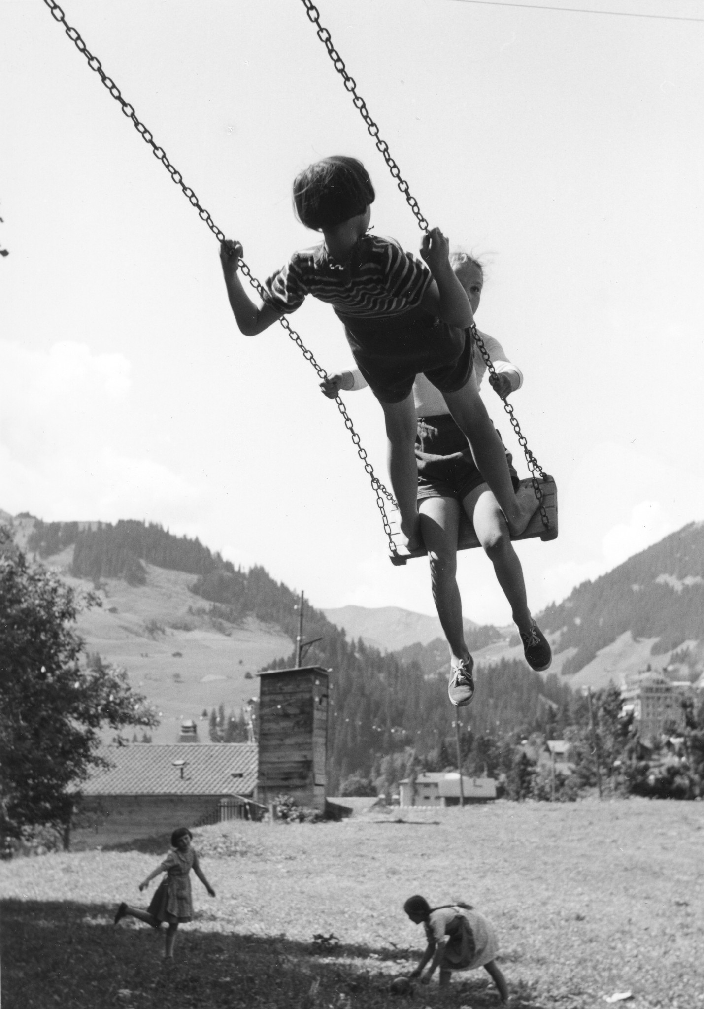 Zwei Kinder spielen auf einer Schaukel