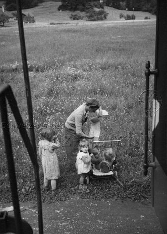 Mutter mit drei Kindern draussen; um 1960