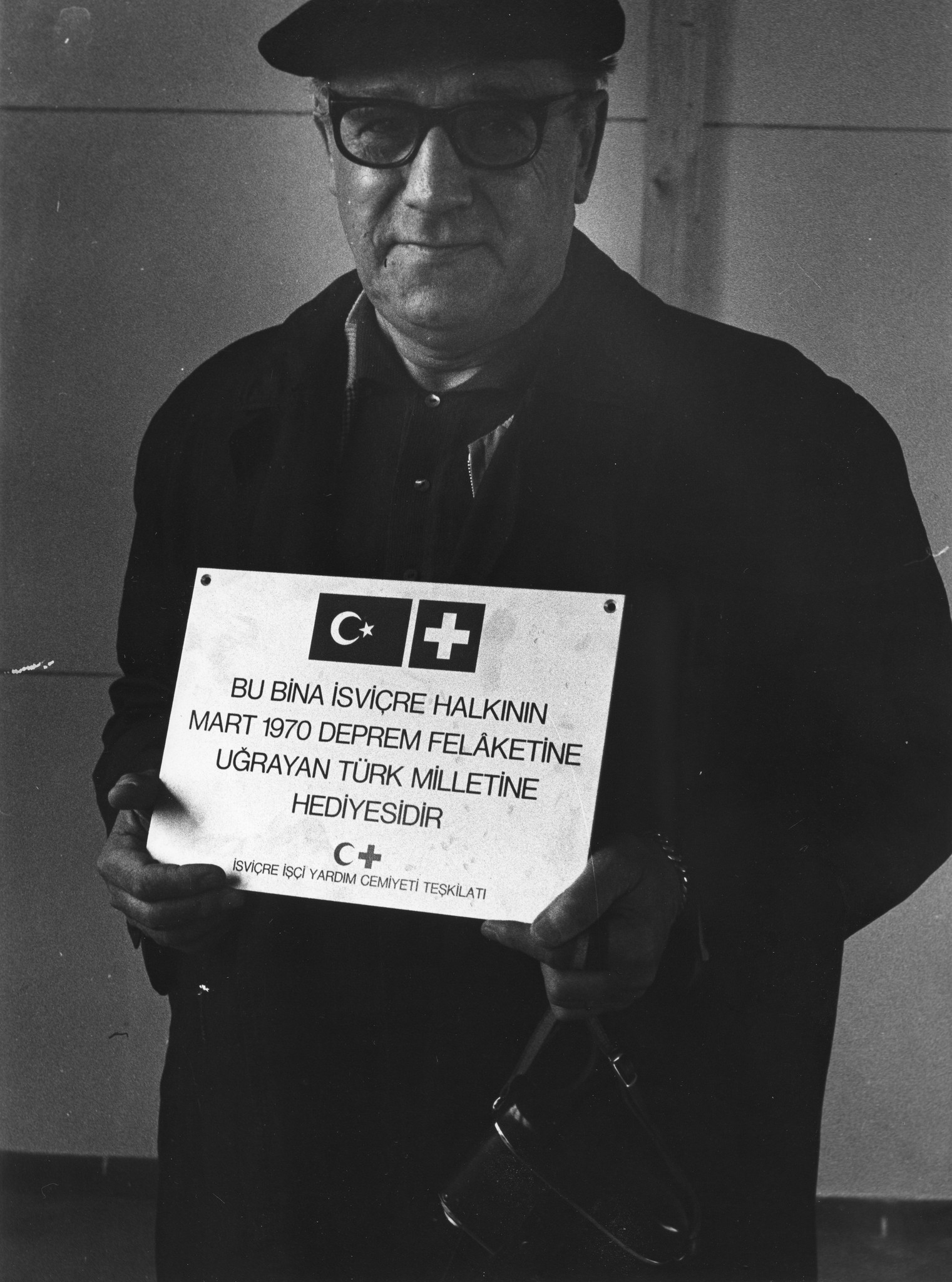 Türkei: Erdbeben; älterer Mann ein Schild (in türkischer Sprache) in den Händen haltend