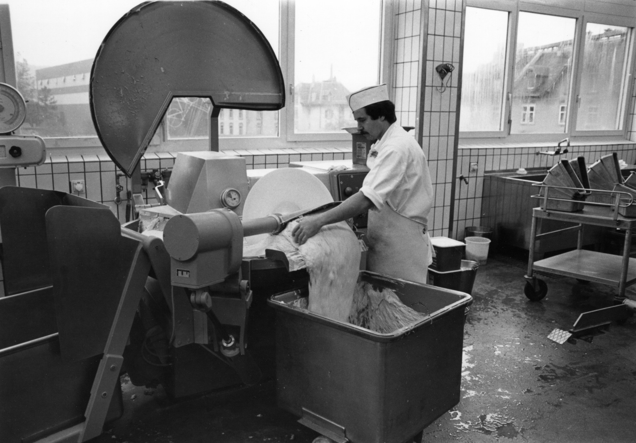 Arbeiter an einer Maschine mit Fleischbrät