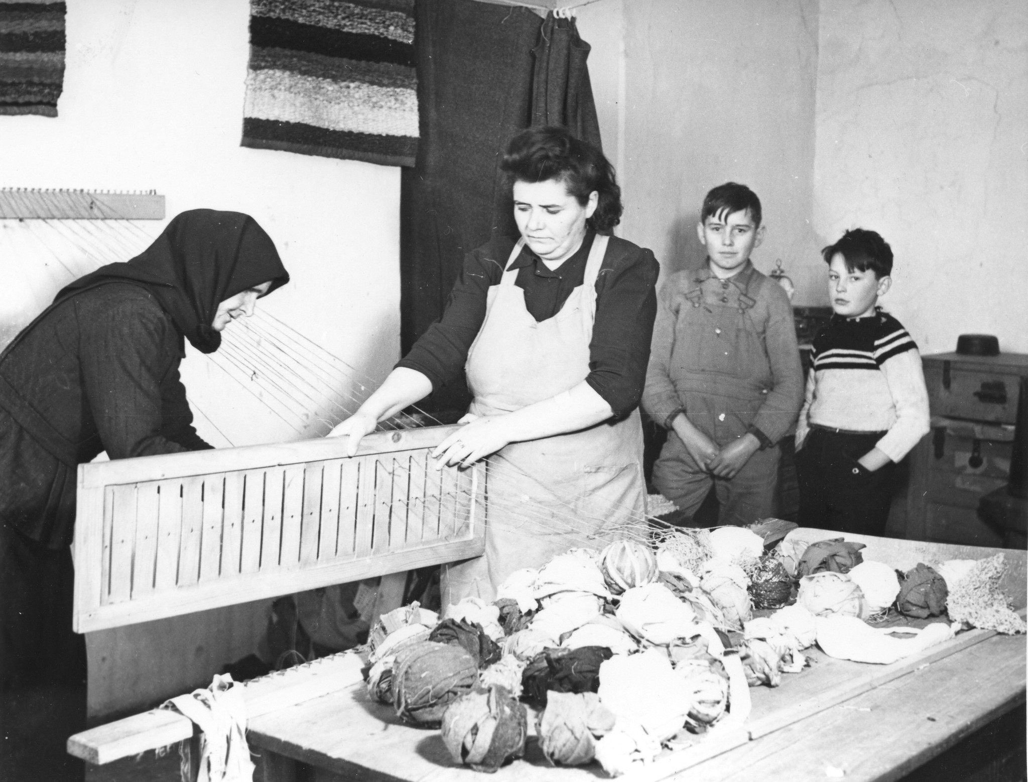 "Aus dem städtischen Flüchtlingslager Wien-Arsenal. Jugoslawische Flüchtlinge beim Weben vom Fleckerlteppichen", Februar 1949