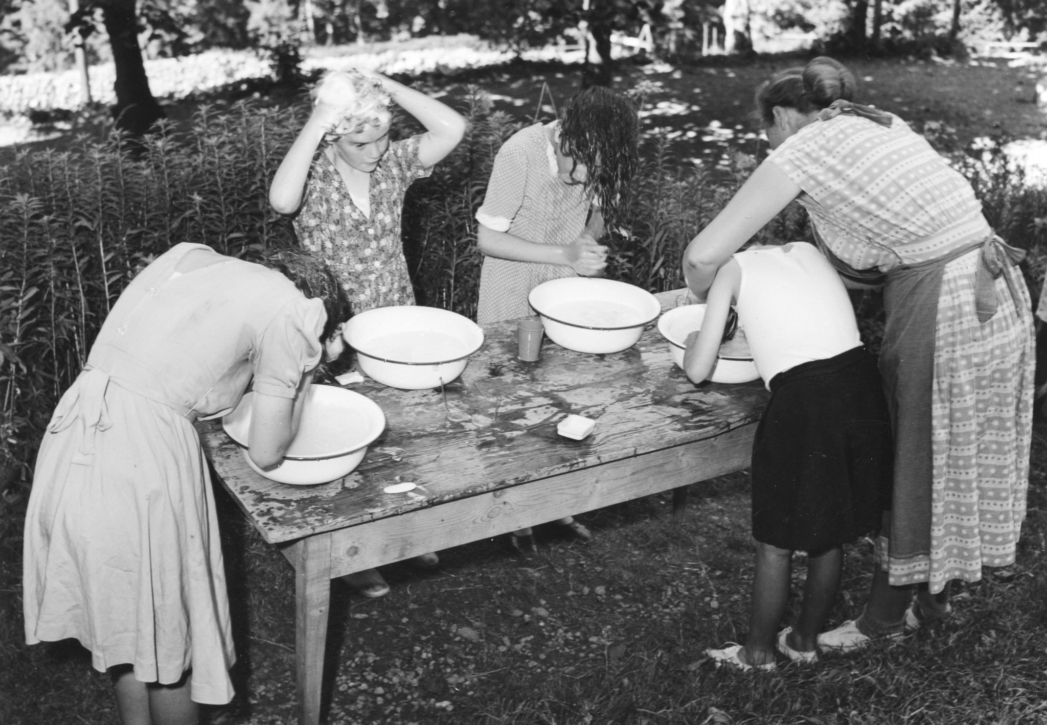 SAH Kinderlager im Sommer 1952 in Kienthal - Mädchen waschen draussen an einem Tisch mithilfe von Schüsseln ihre Haare