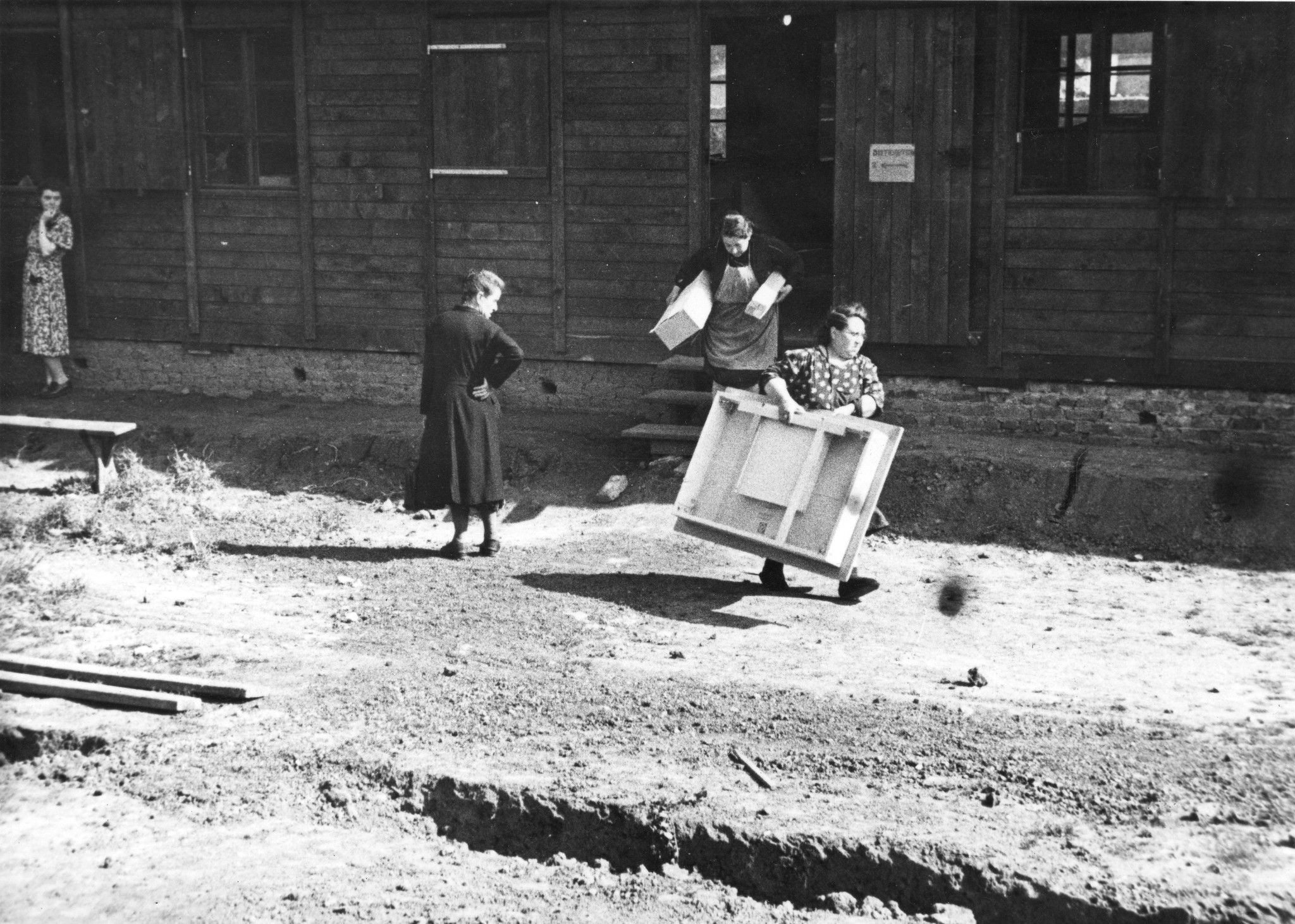"Fives [Stadtviertel von Lille, Nord-Pas-de-Calais] Möbelverteilung", zwei Frauen tragen Möbelstücke, vermutlich im SAH-Sozialzentrum, um 1946
