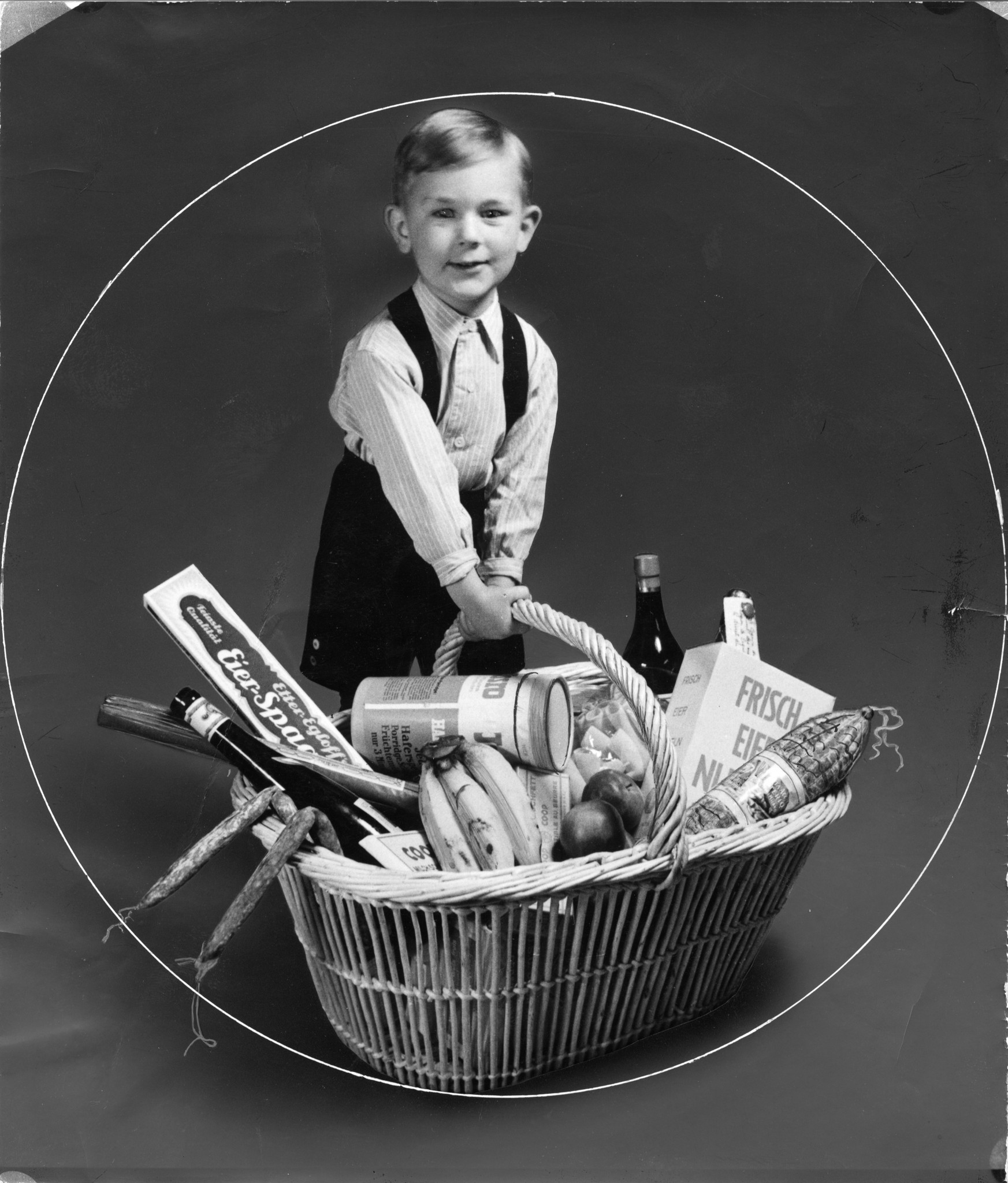 Knabe einen Lebensmittelkorb (Früchte, Spaghetti, Fleisch, Wein) haltend, 1940