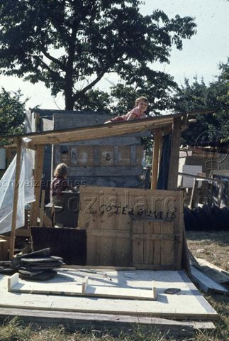 "Bauspielplatz Binningen" - Kinder in und auf einer Holzhütte; um 1975