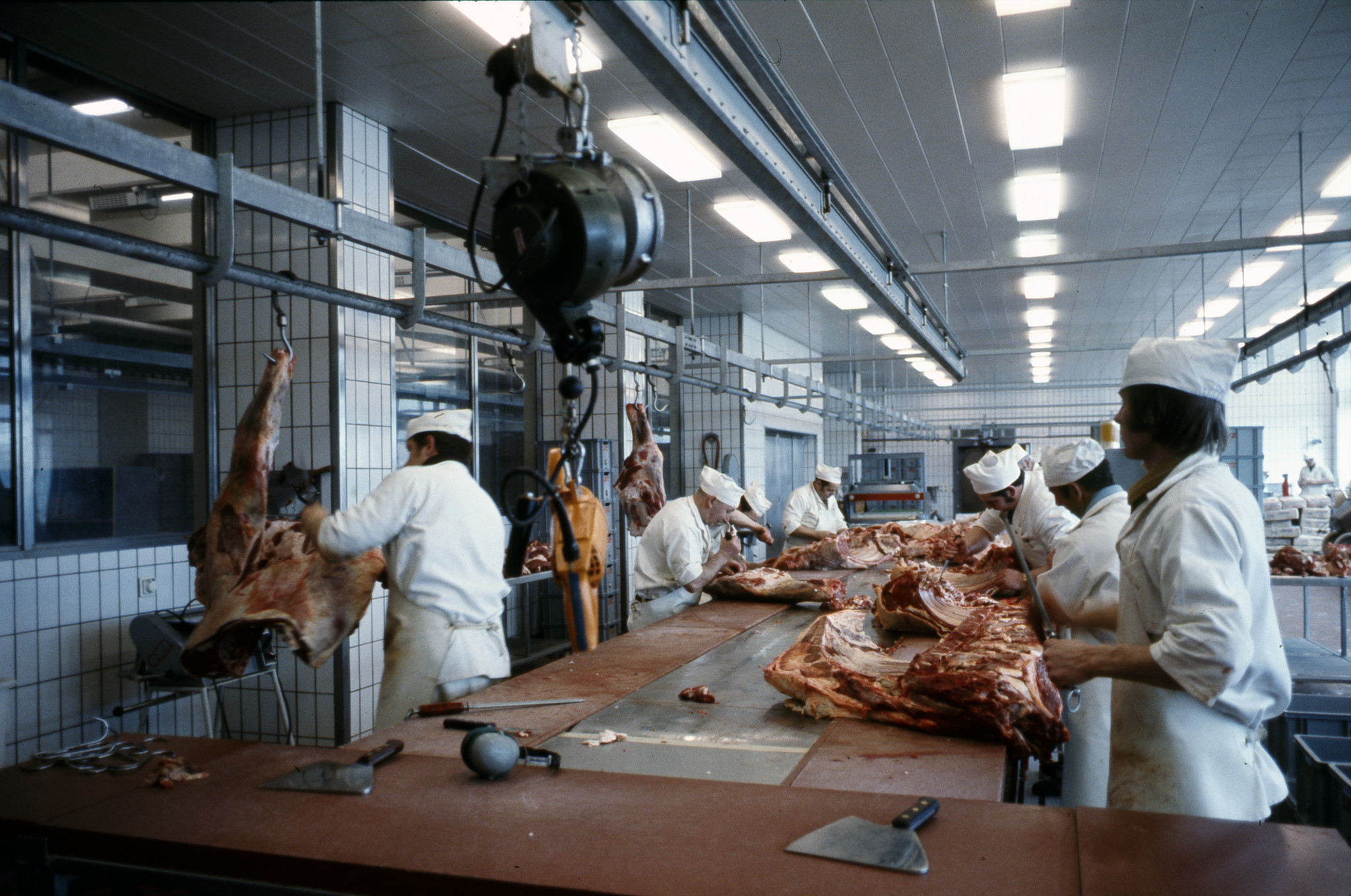 Metzger beim Zerteilen von Fleisch, ca. 1980