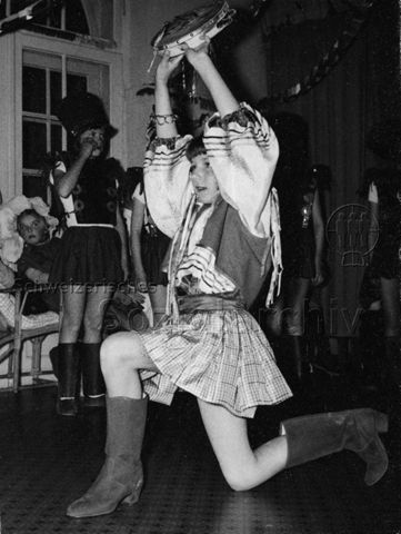 "FZA Zirkus" - Mädchen in einer Tracht bei einer Aufführung mit dem Tamburin; um 1970