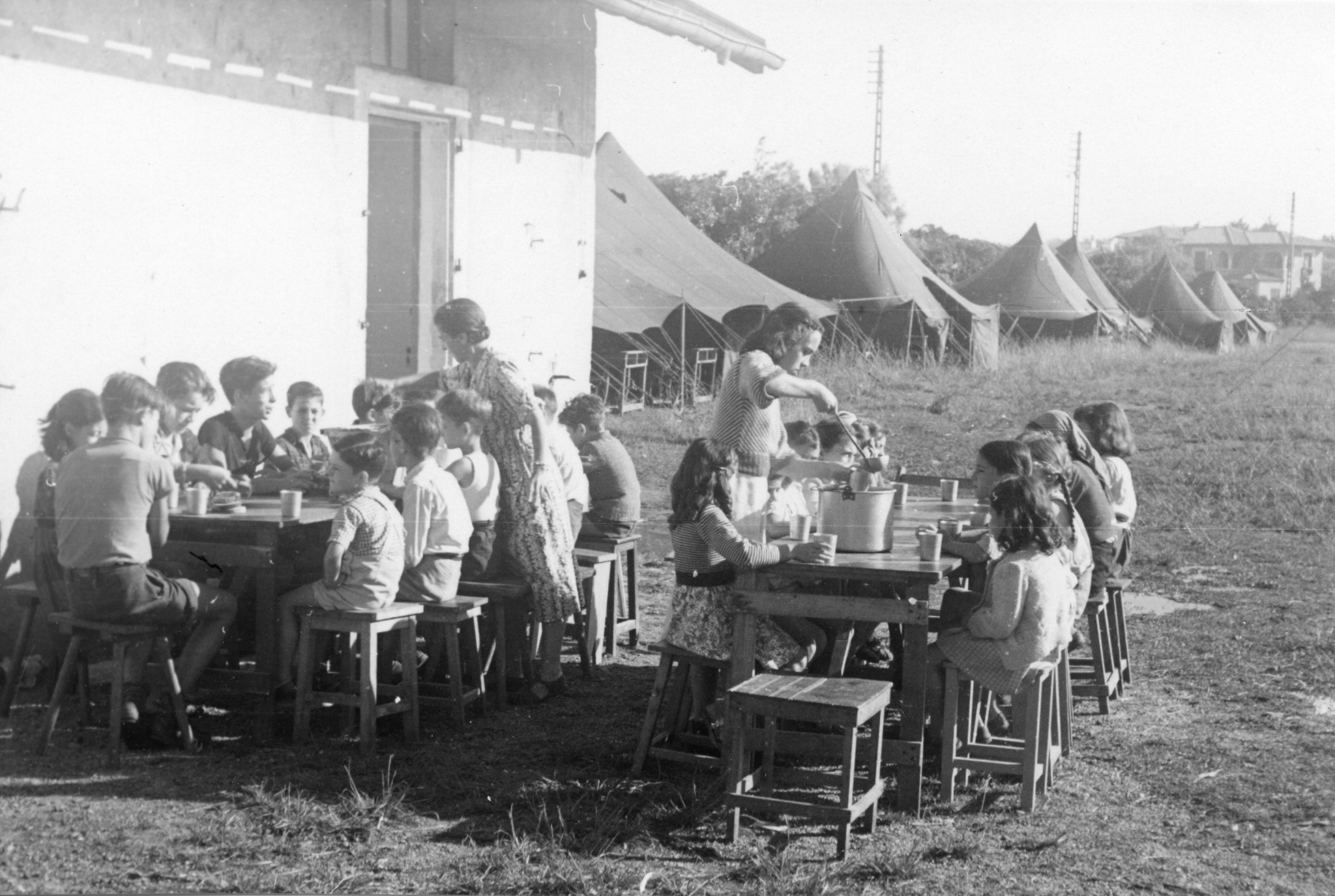 "Colonie de vacances St. Pierre d'Irube 17.8 bis 17.9.1948 Europahilfe"; zwei Betreuerinnen geben das Essen aus