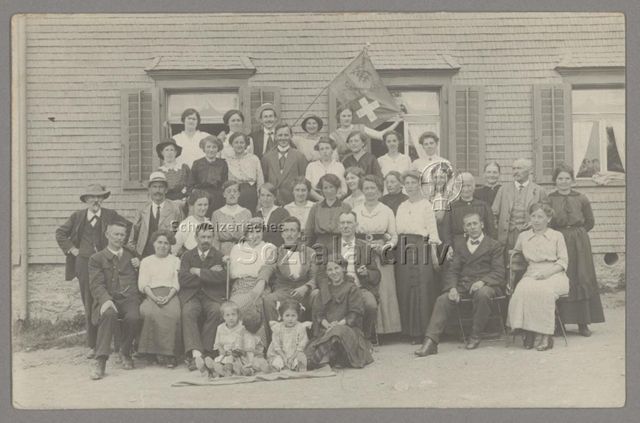 Gruppenfoto mit Fahne vor einem Haus, Ferien in Gamperdon, 20.06.1915
