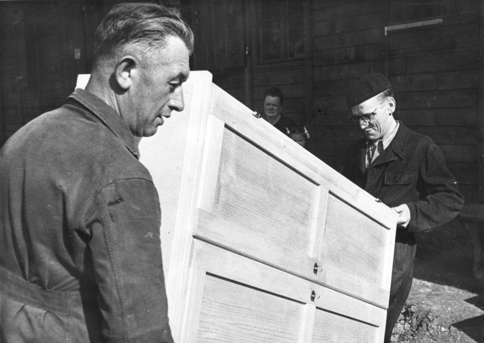 "Fives [Stadtviertel von Lille, Nord-Pas-de-Calais] Möbelverteilung", zwei Männer tragen einen Schrank, vermutlich im SAH-Sozialzentrum, um 1946
