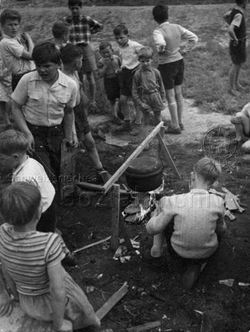 "Wipkingen", wahrscheinlich auf dem Robinsonspielplatz - Kinder und Jugendliche kochen über dem Feuer; um 1965