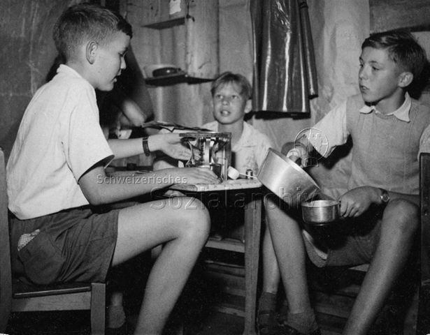 Jungen beim Kochen von Wasser, wahrscheinlich in einem Freizeitzentrum; um 1965