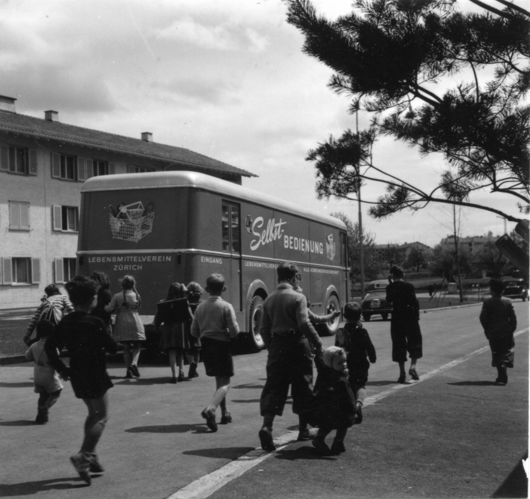 Kinder vor einem Verkaufswagen des Lebensmittelvereins Zürich