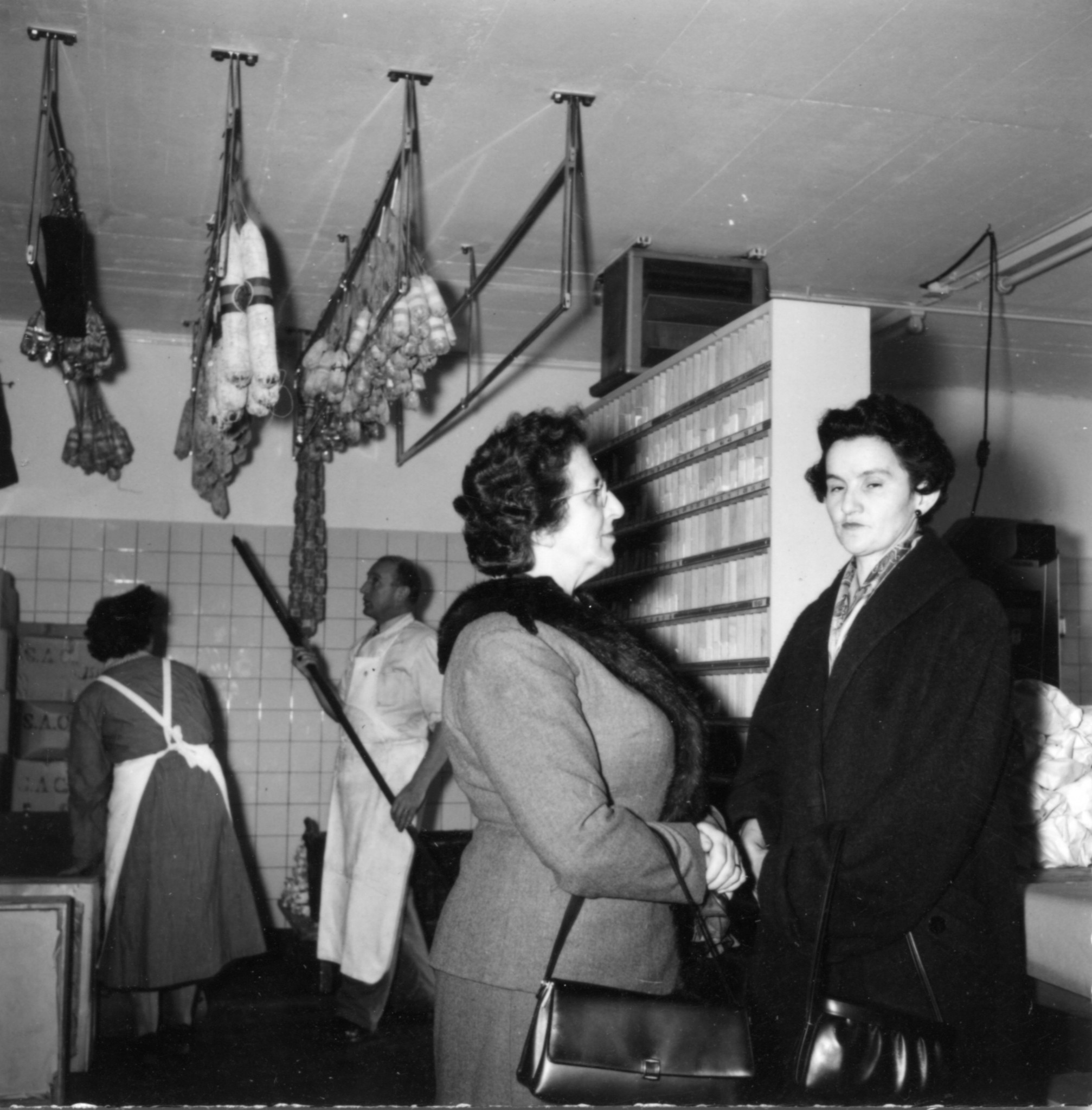 Frauen in einem Produktionsbetrieb mit Wurstwaren an der Decke