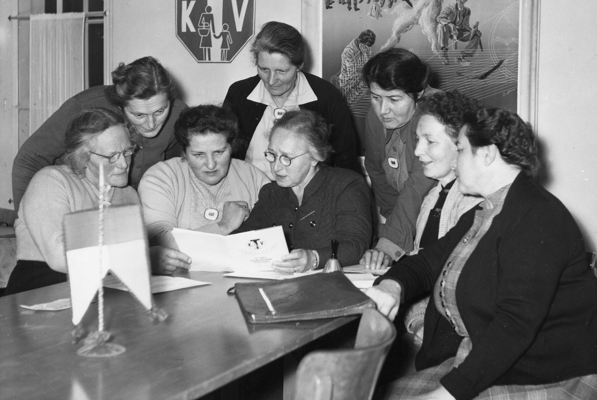 In den Räumlichkeiten des Konsumvereins (KV) studieren Frauen ein Dokument, um 1940