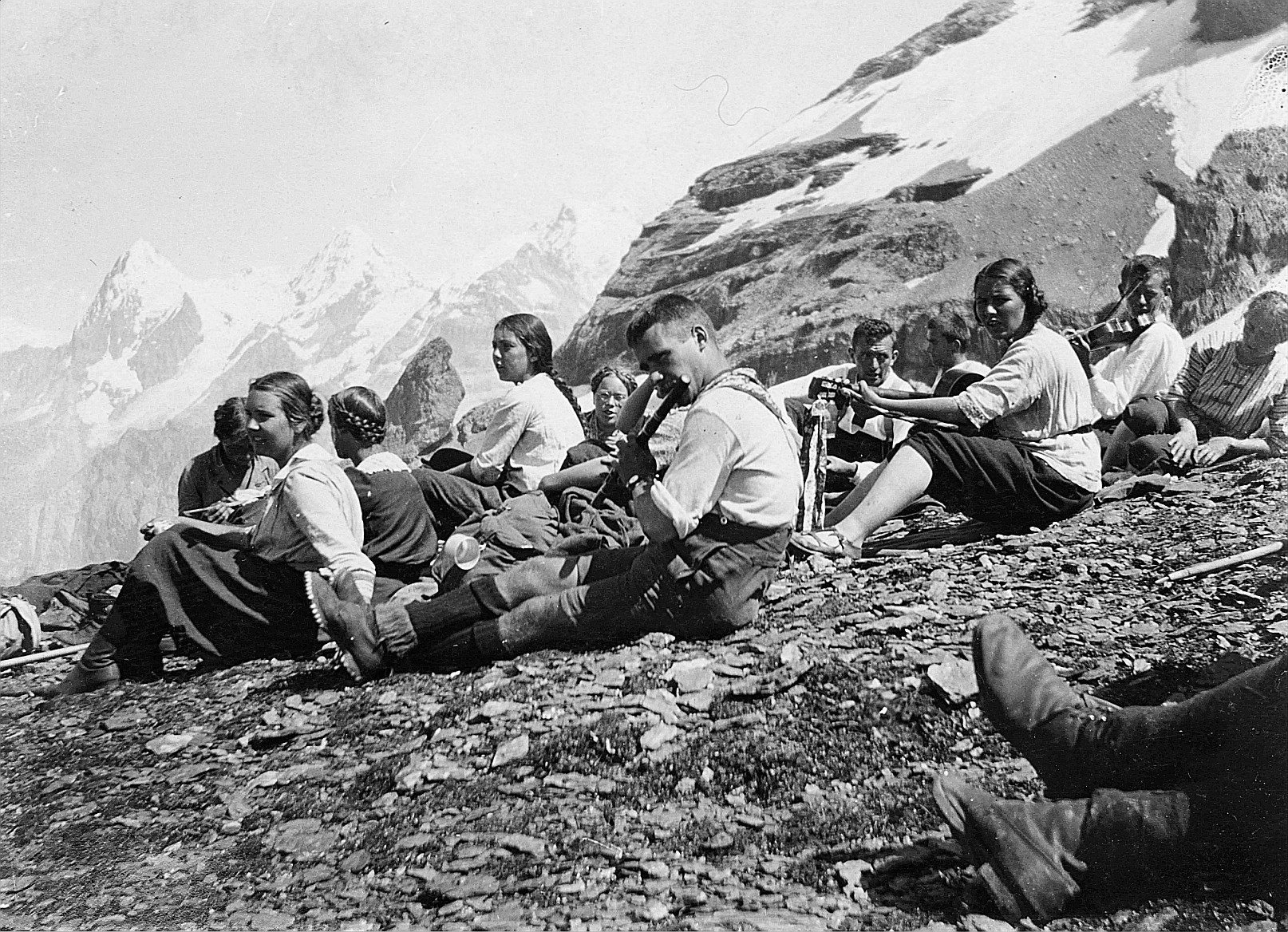 Bei einer Rast (vermutlich) während einer Wanderung: Wandervögel spielen Gitarre, Geige und Querflöte - Vor der Sefinenfurgge [Sefin