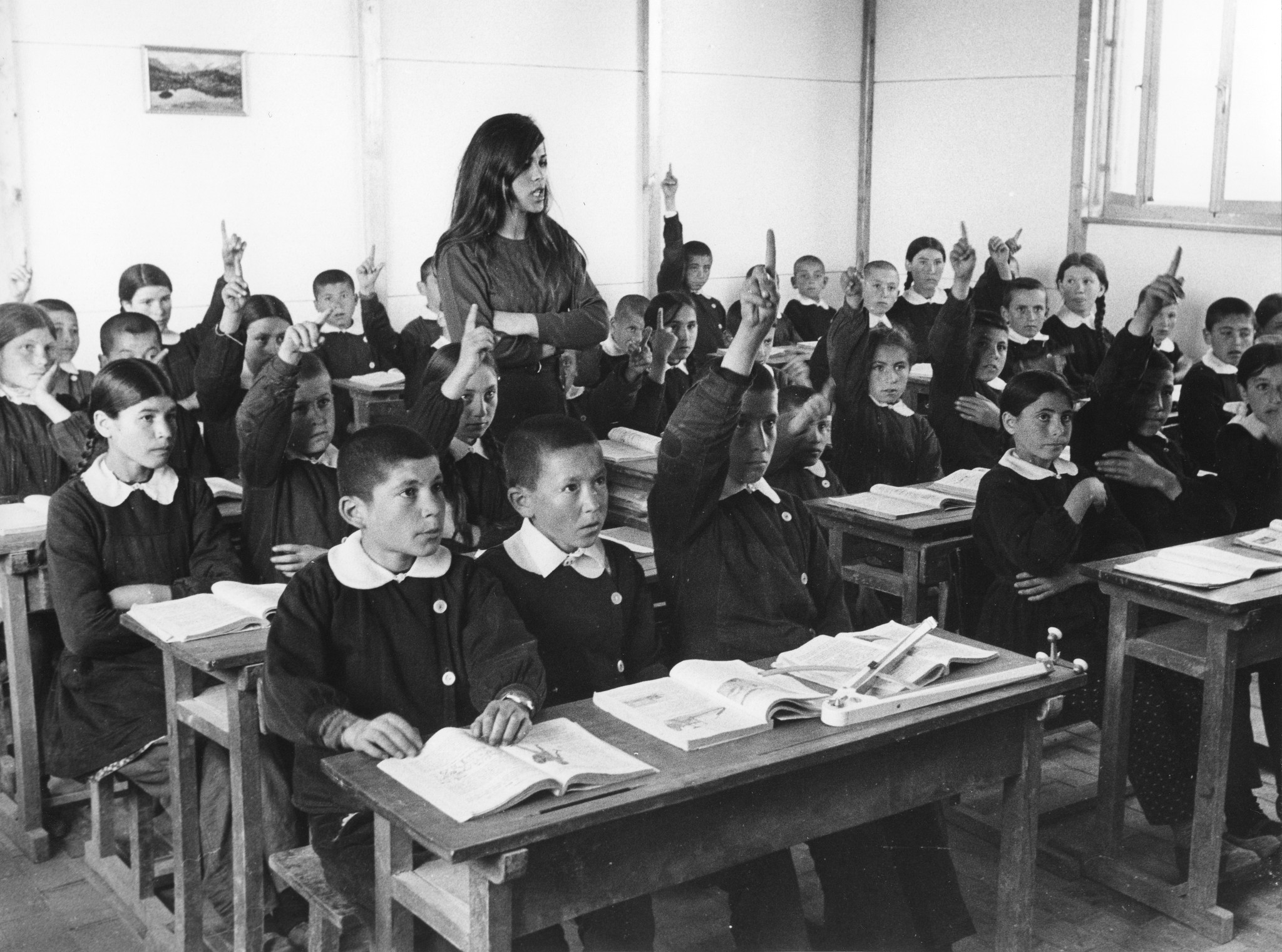 Schüler, Schülerinnen und eine Lehrerin während des Unterrichts in einem Schulzimmer