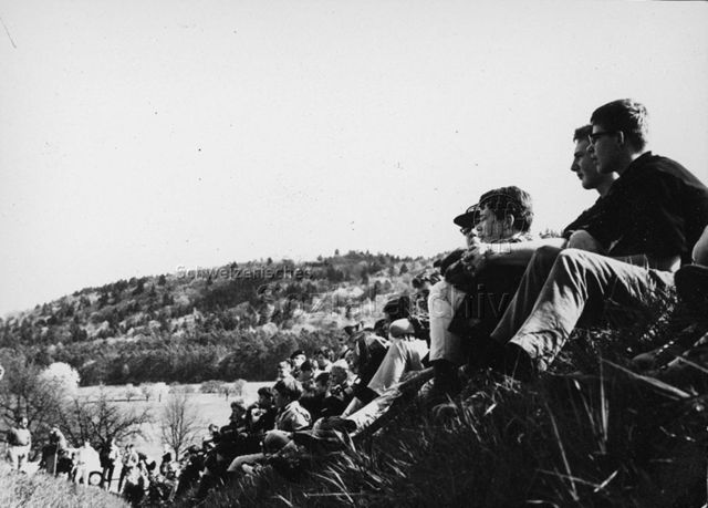 Junge Leute im Gras sitzend und etwas beobachtend, um 1965