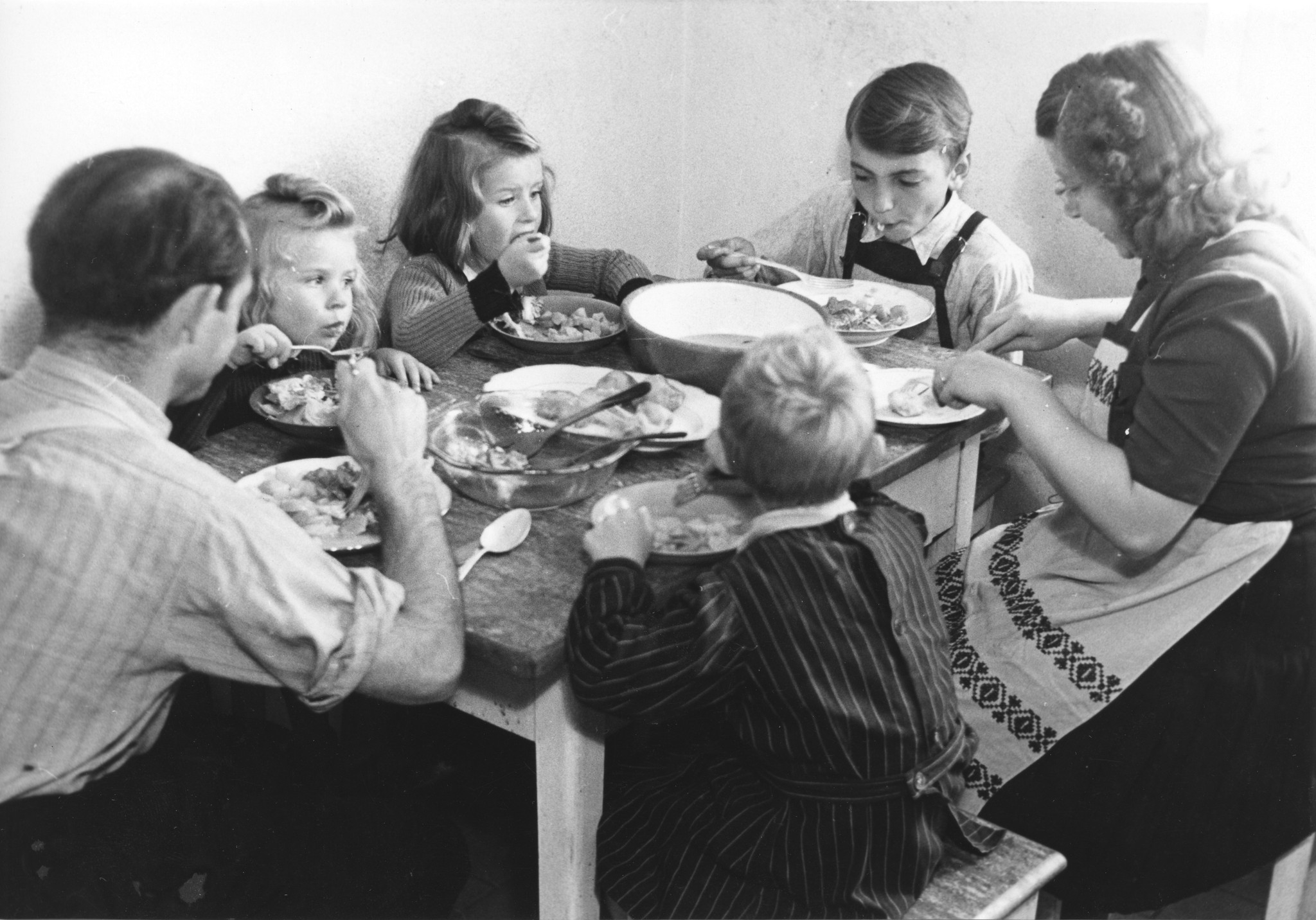 "Wie ganz anders war doch der helle, heimelige Mittagstisch bei der Familie B. im Friesenberg!", vgl. Sozarch_F_5025-Fb-406, Schweizerfamilie beim Essen mit Wiener Arbeiter Kindern, Zürich 1946