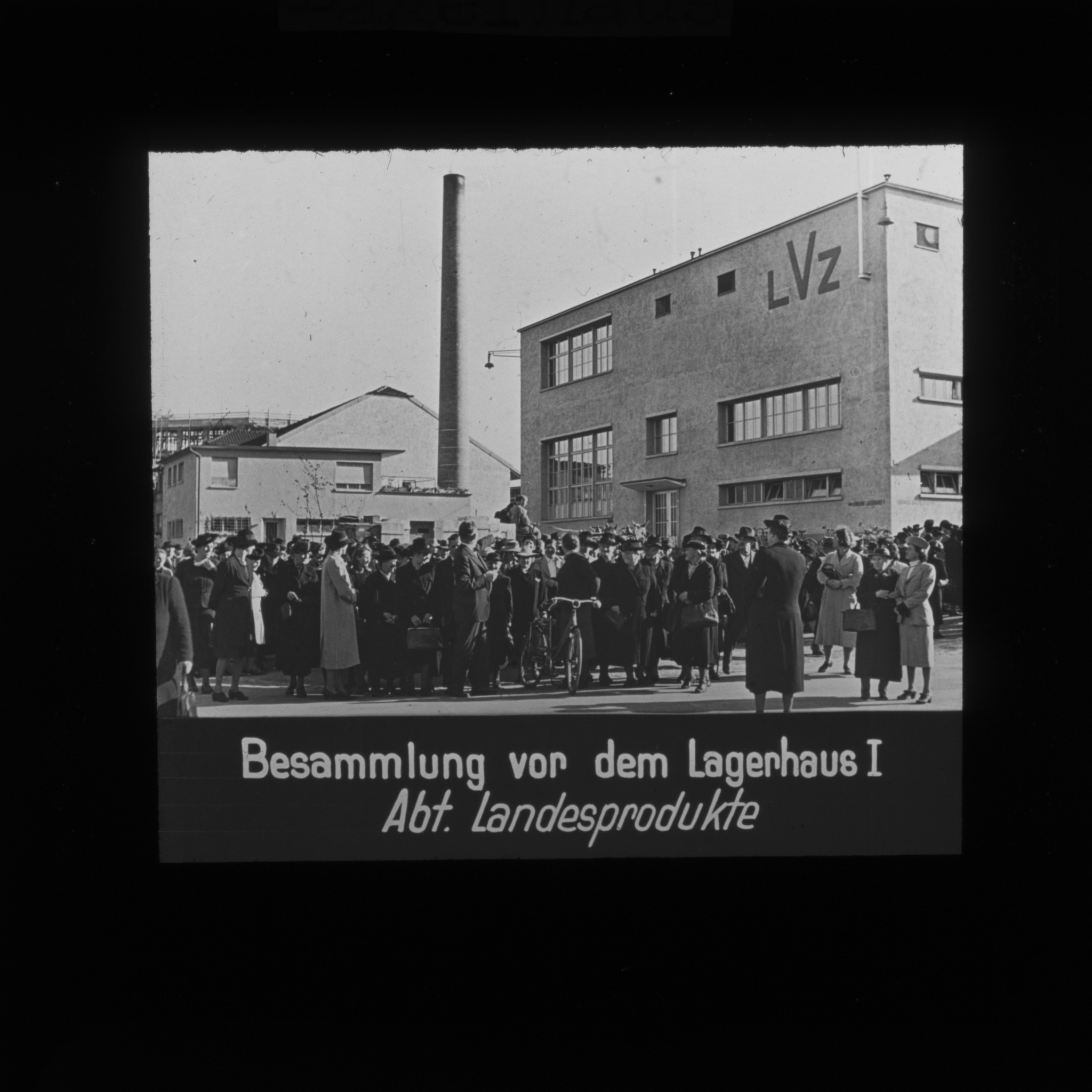 Dia: Lagerhaus an der Turbinenstrasse, davor viele Menschen stehend: "Besammlung vor dem Lagerhaus I. Abt. Landesprodukte".