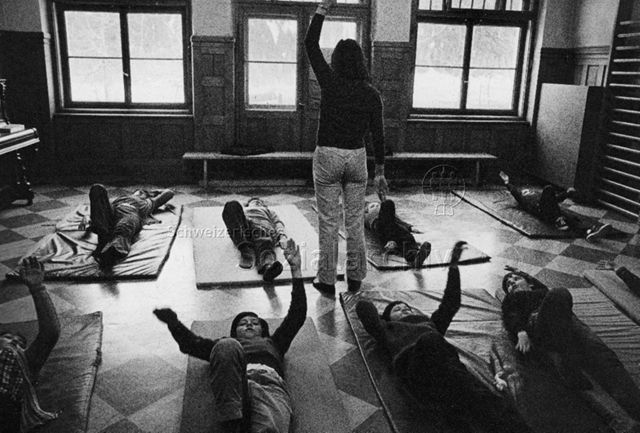 "Kinderheilstätte [Davos], Asthma-Gymnastik" - Kinder machen Übungen, die Leiterin gibt Anweisungen; 1971