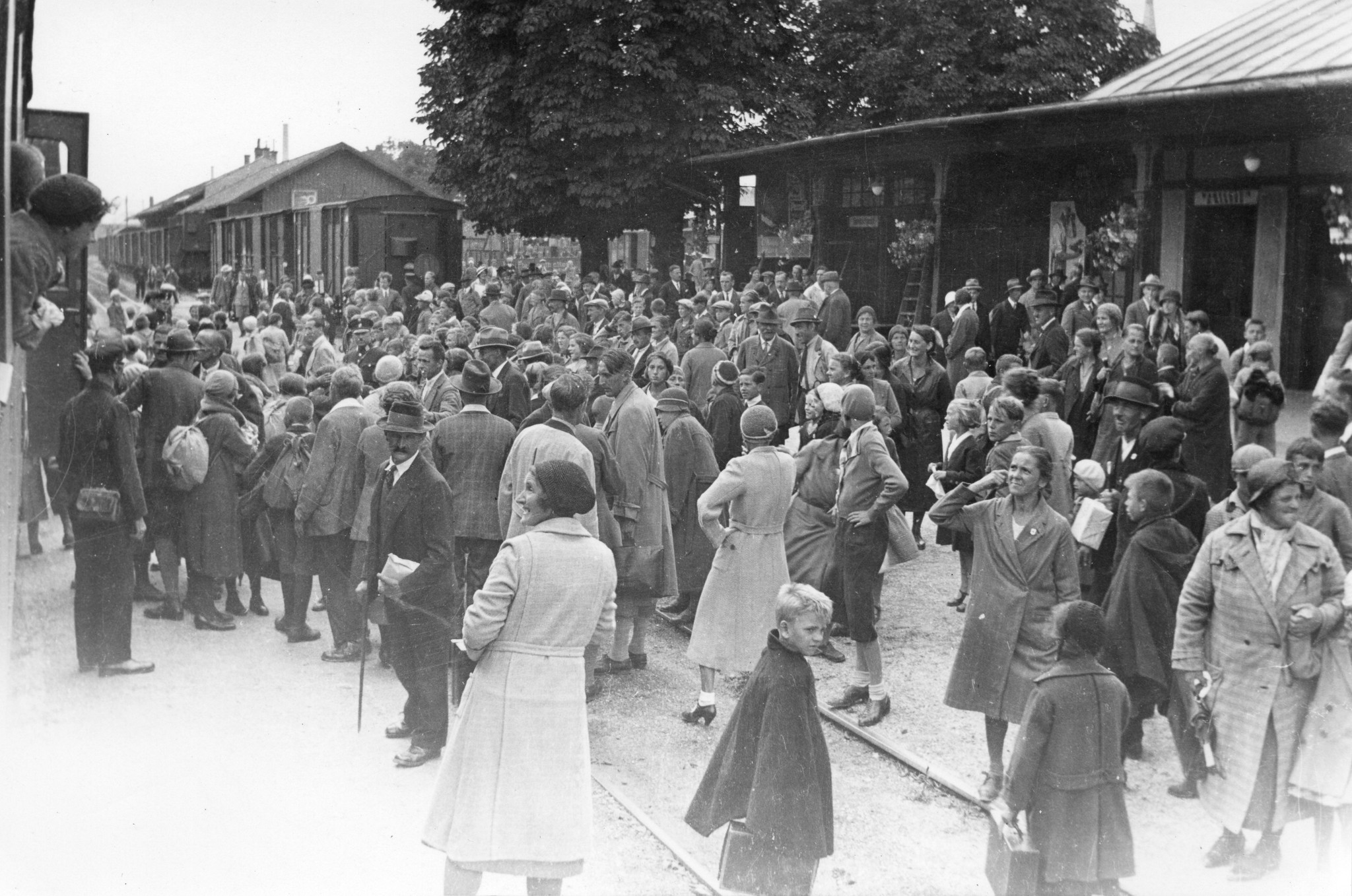 Menschenanhäufung am Bahnhof beim Abfahrt (vermutlich) der Steyrer Kinder für die Schweiz, in einem ehemaligen Gefangenenlager (Ennsleitn) wo Familien wohnen, um 1950 (Nachkriegszeit)
